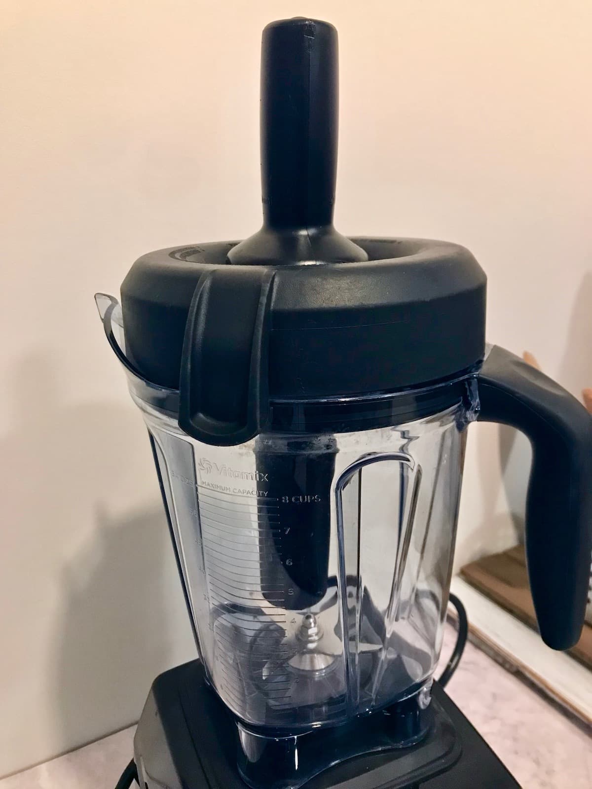 A Vitamix blender with a tamper in it.