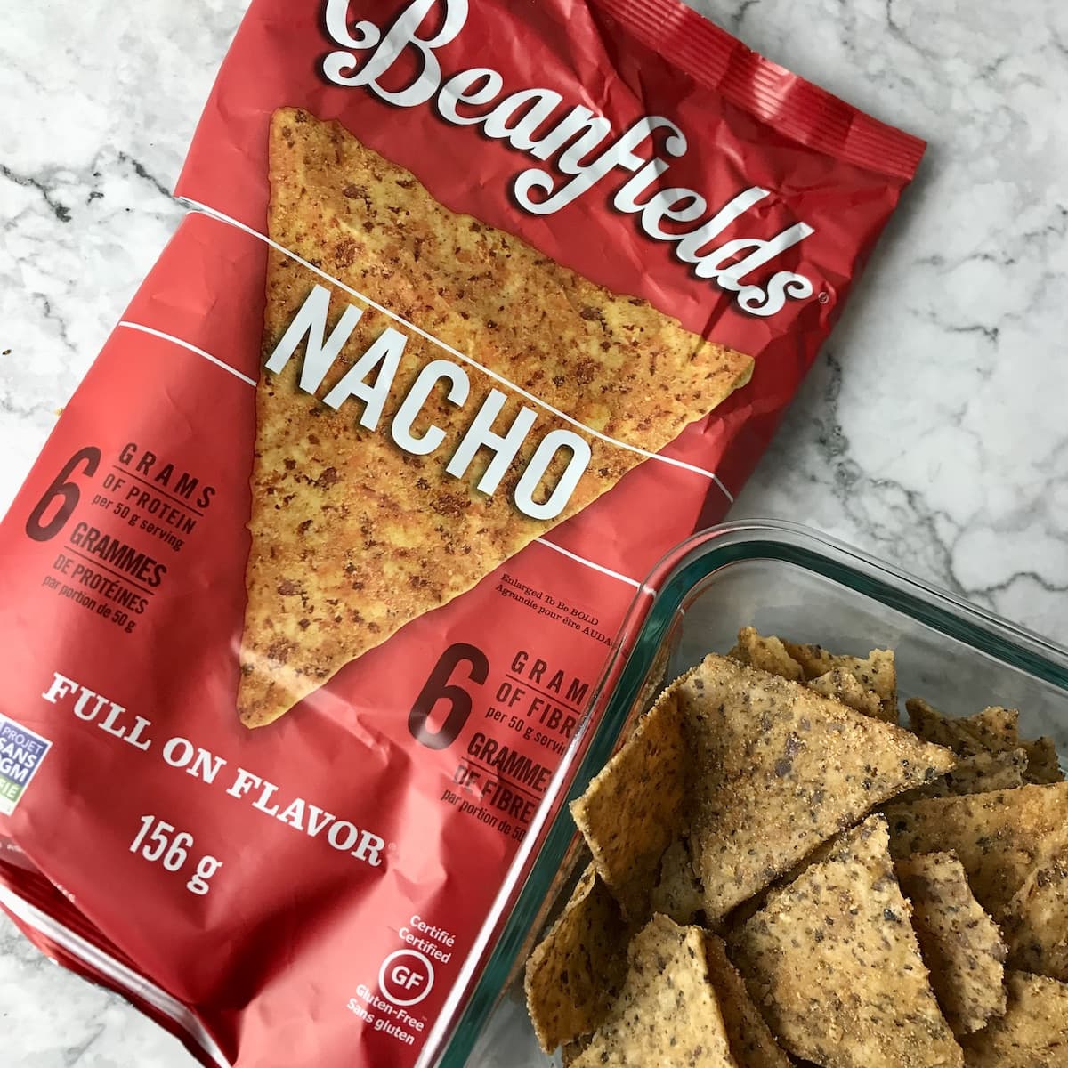 A bag of Beanfields Nachos next to a container of them.