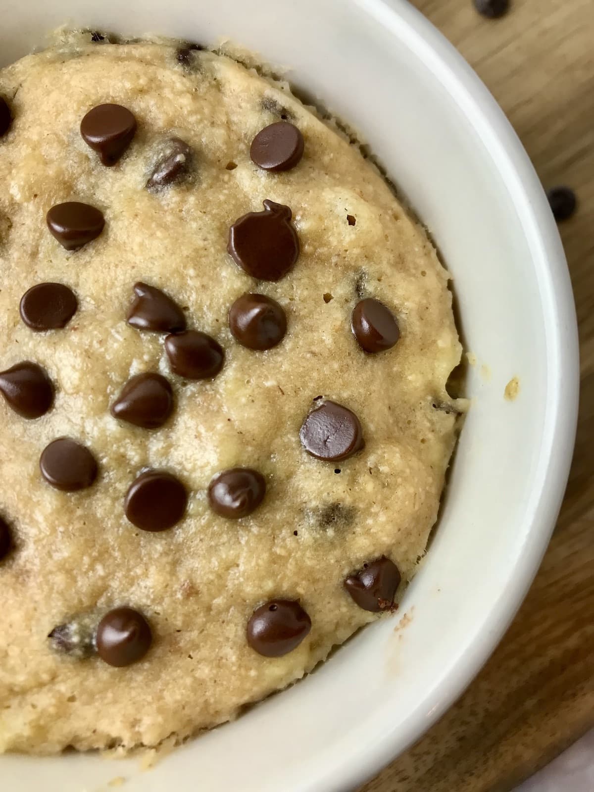 A banana chocolate chips mug cake in a white ramekin.