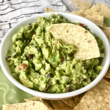 Black bean guacamole with a tortilla chip in it.