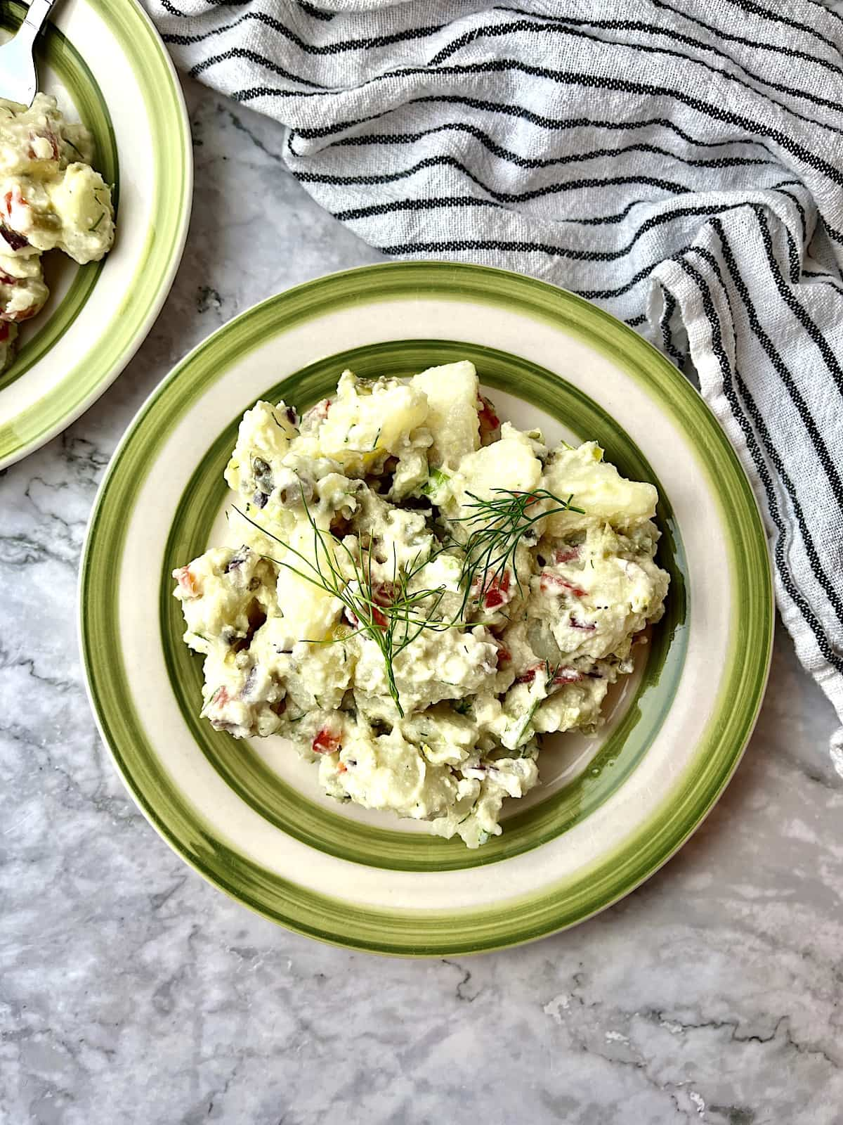 Vegan potato salad topped with fresh dill.