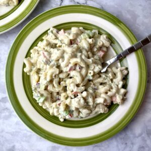 A plate of creamy vegan macaroni with a fork in it.