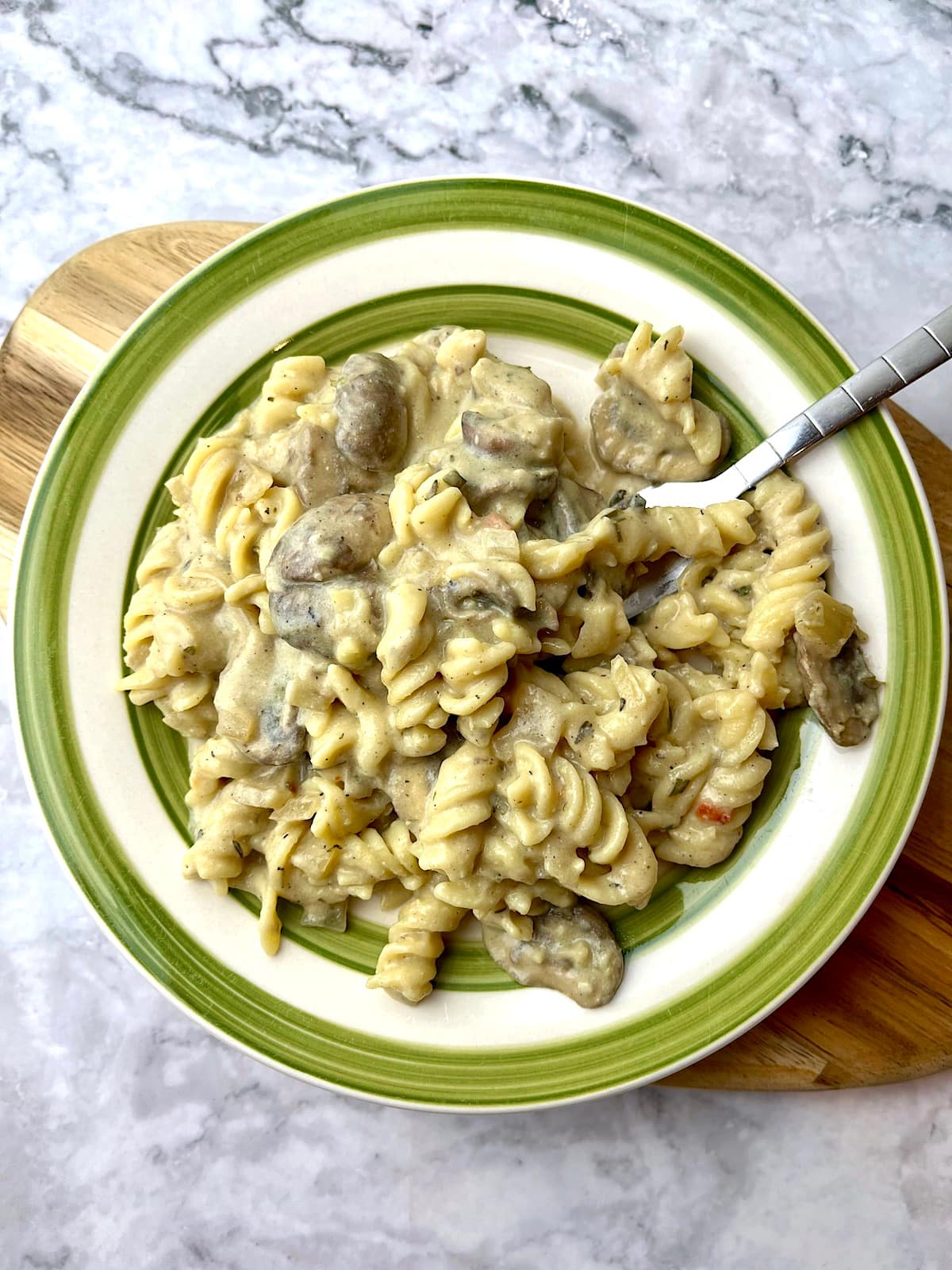 A plate of vegan mushroom stroganoff with fusilli pasta.