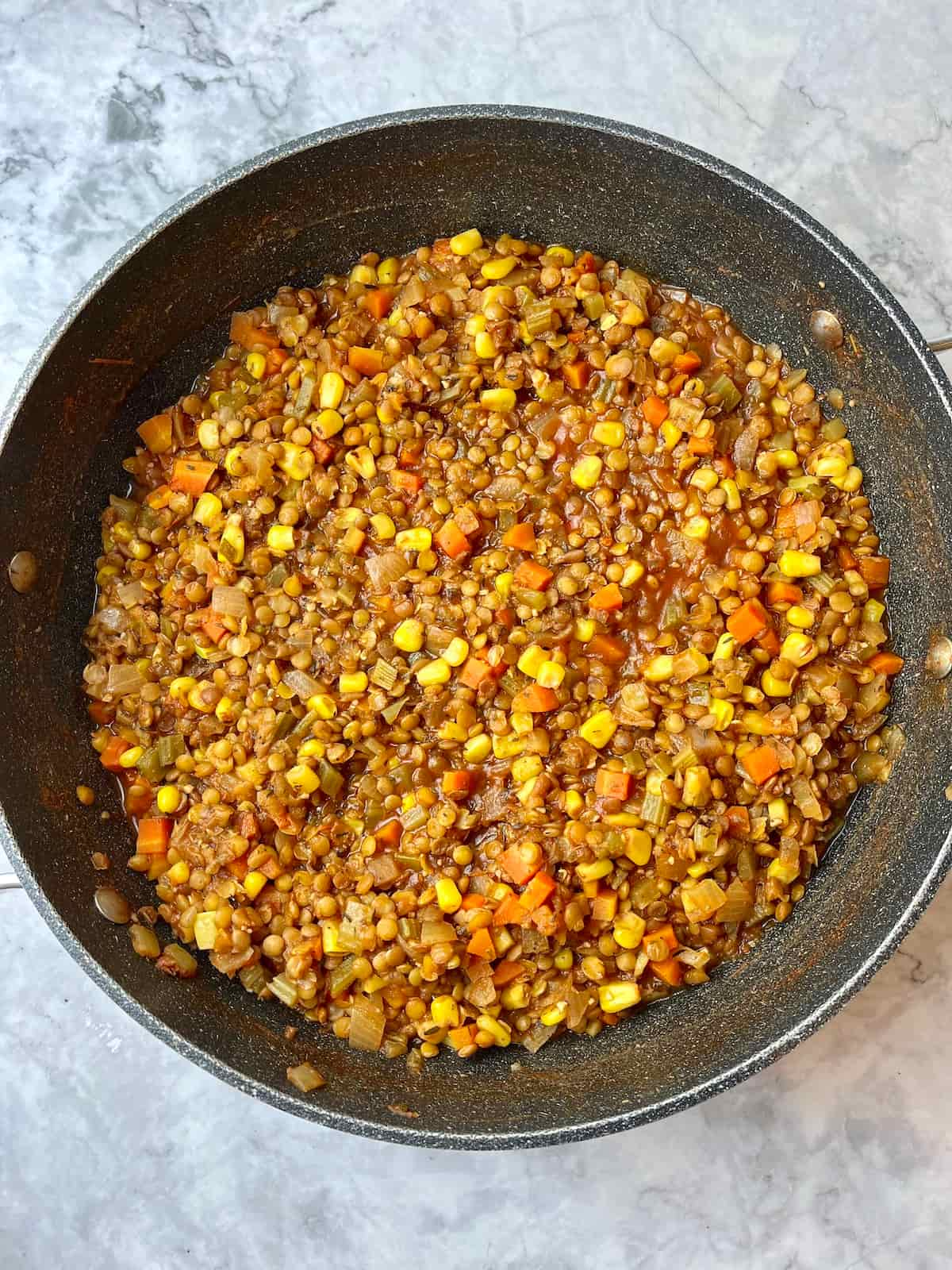 Lentil shepherd's pie filling in a round pan.