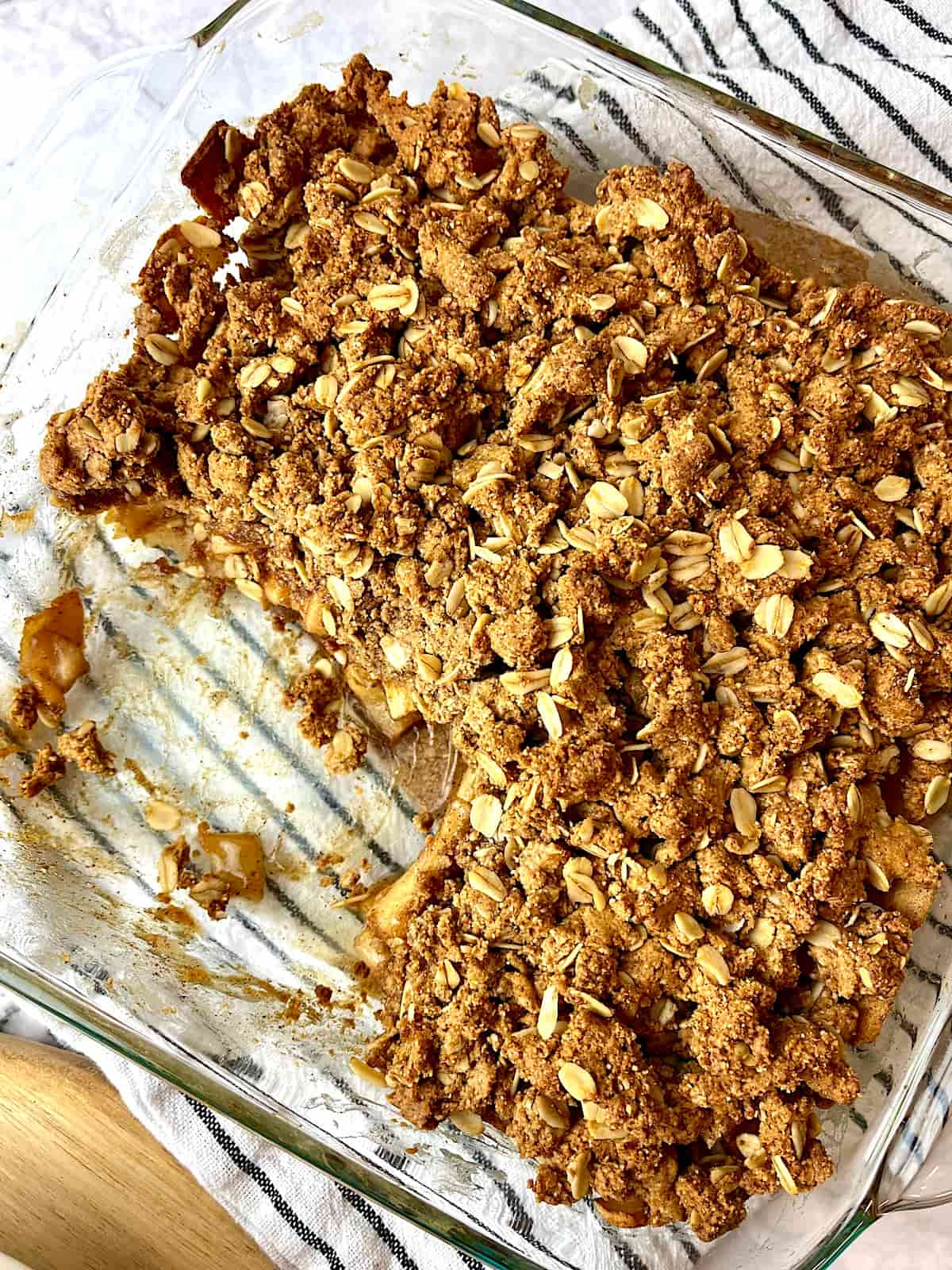 A dish of peanut butter apple crisp with a piece cut out.