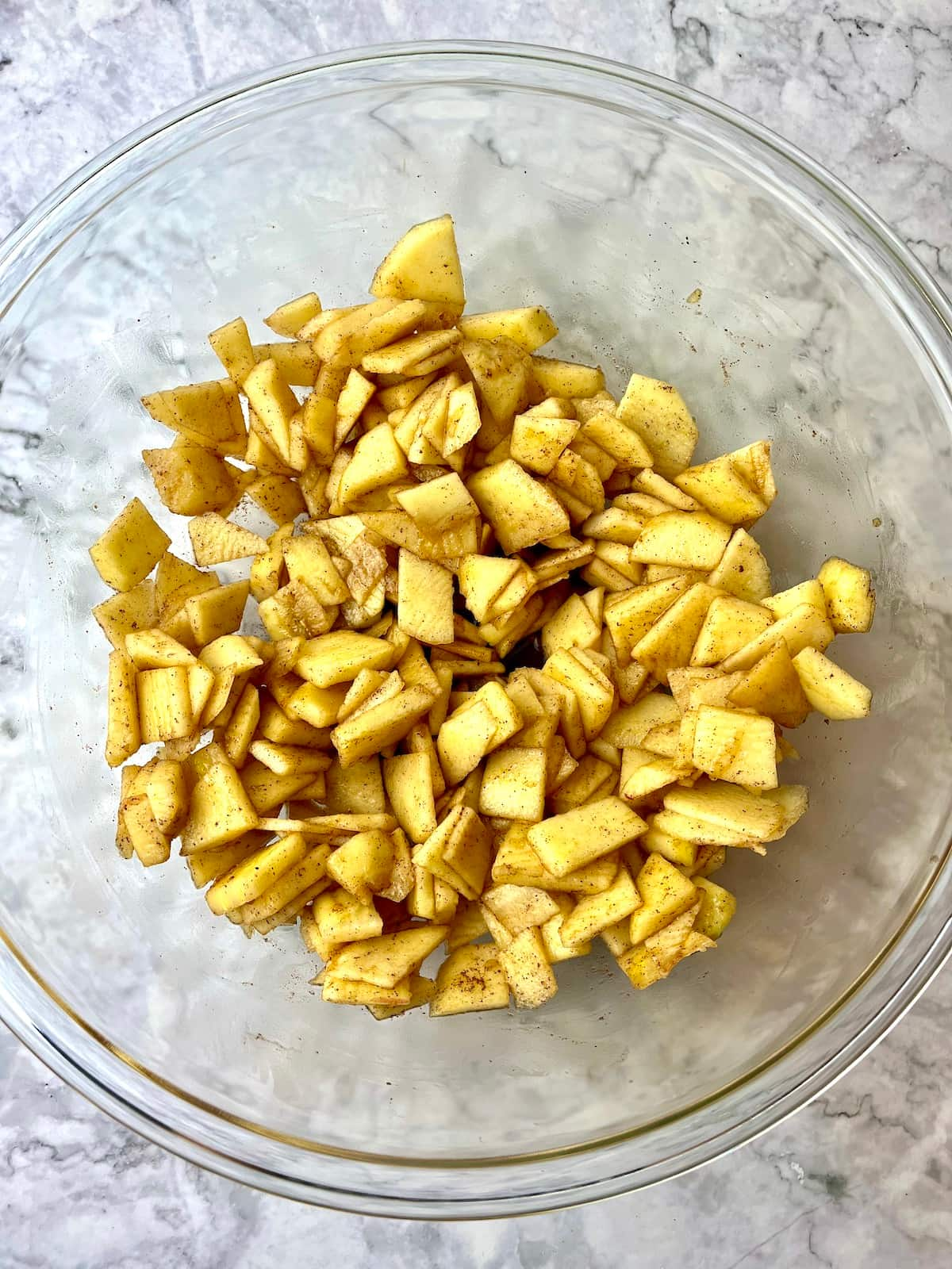 A bowl of chopped apples covered in cinnamon.