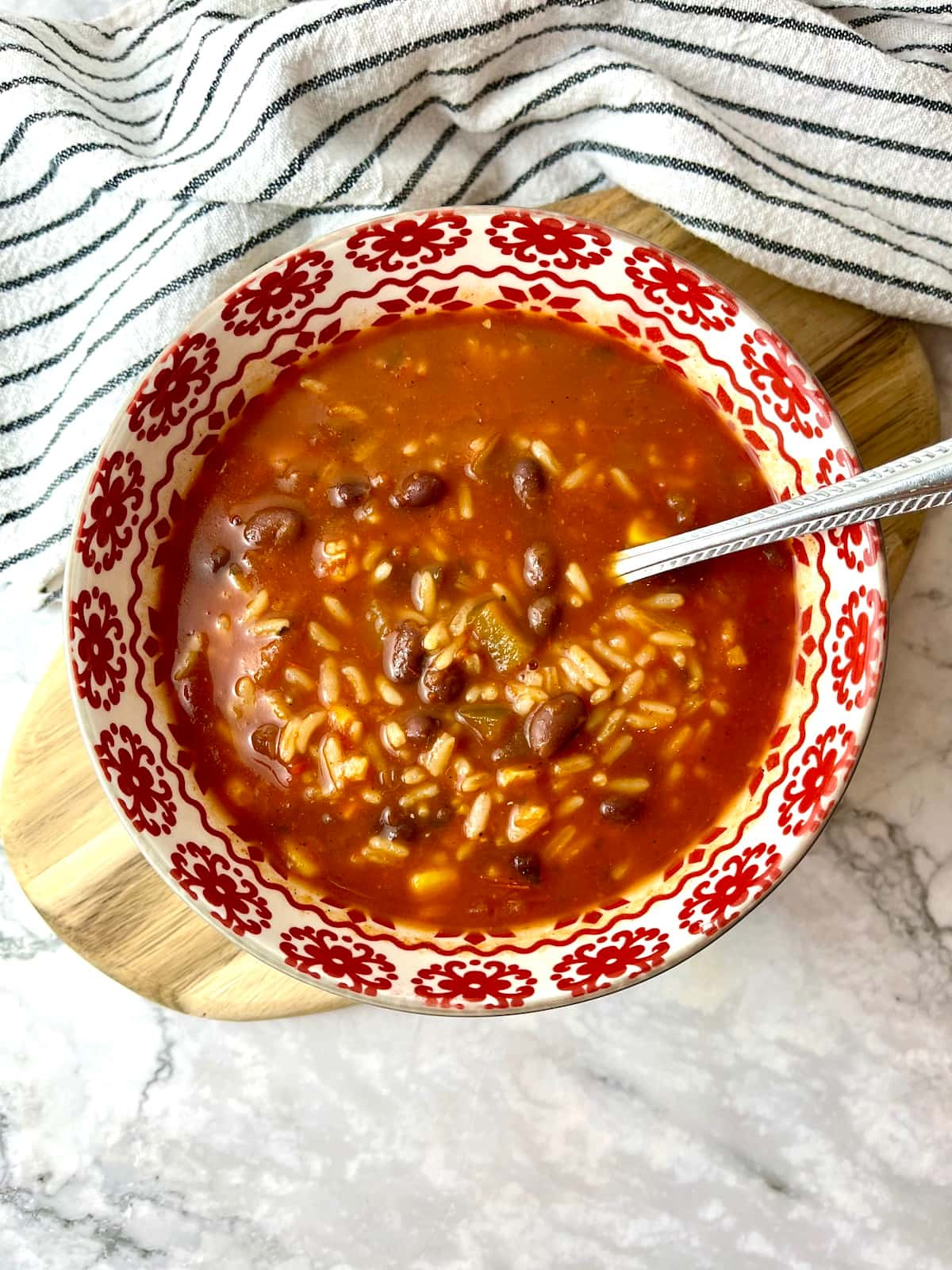 A bowl of salsa soup with rice and beans.