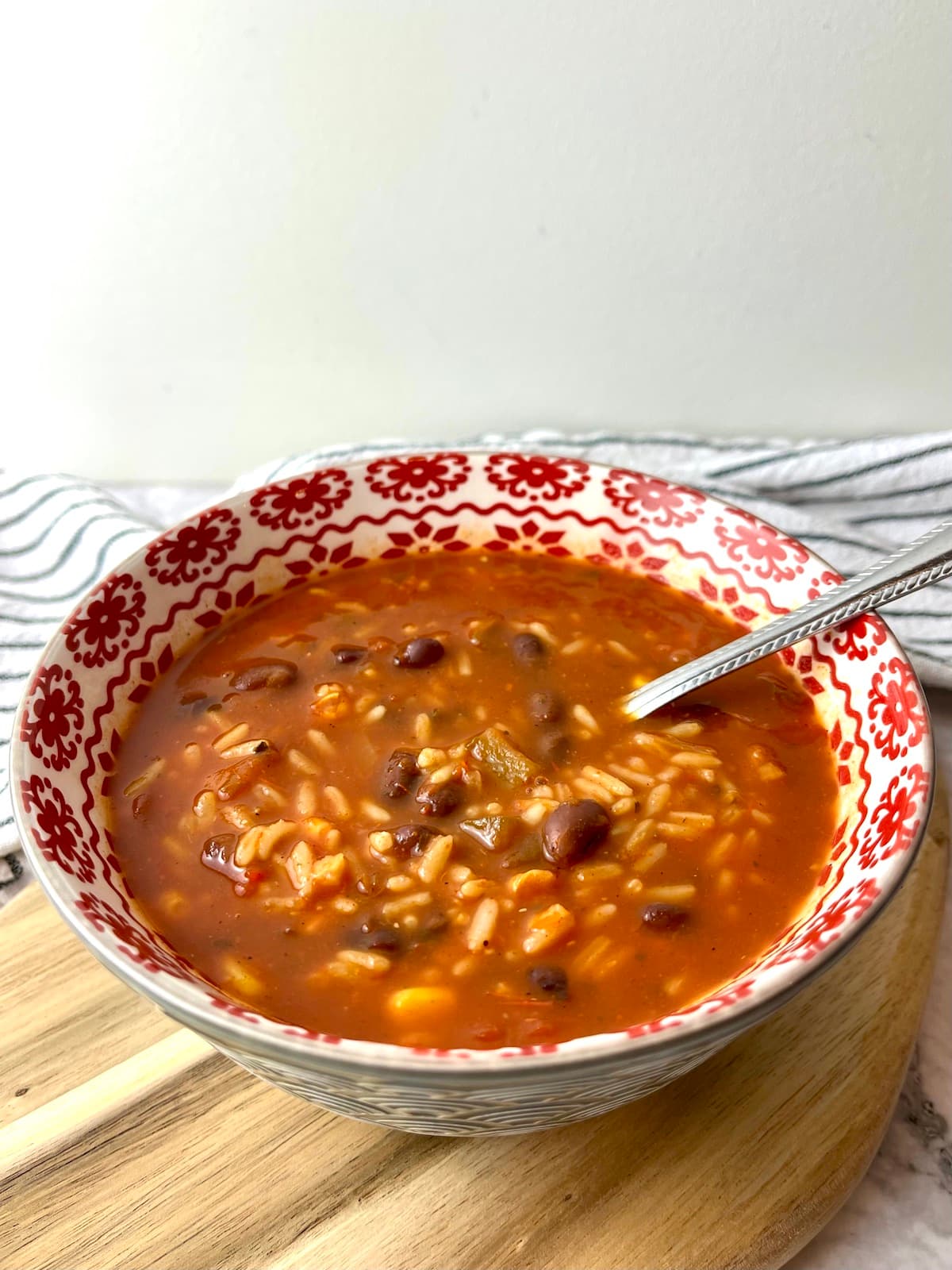 A bowl of salsa soup with rice and black beans.