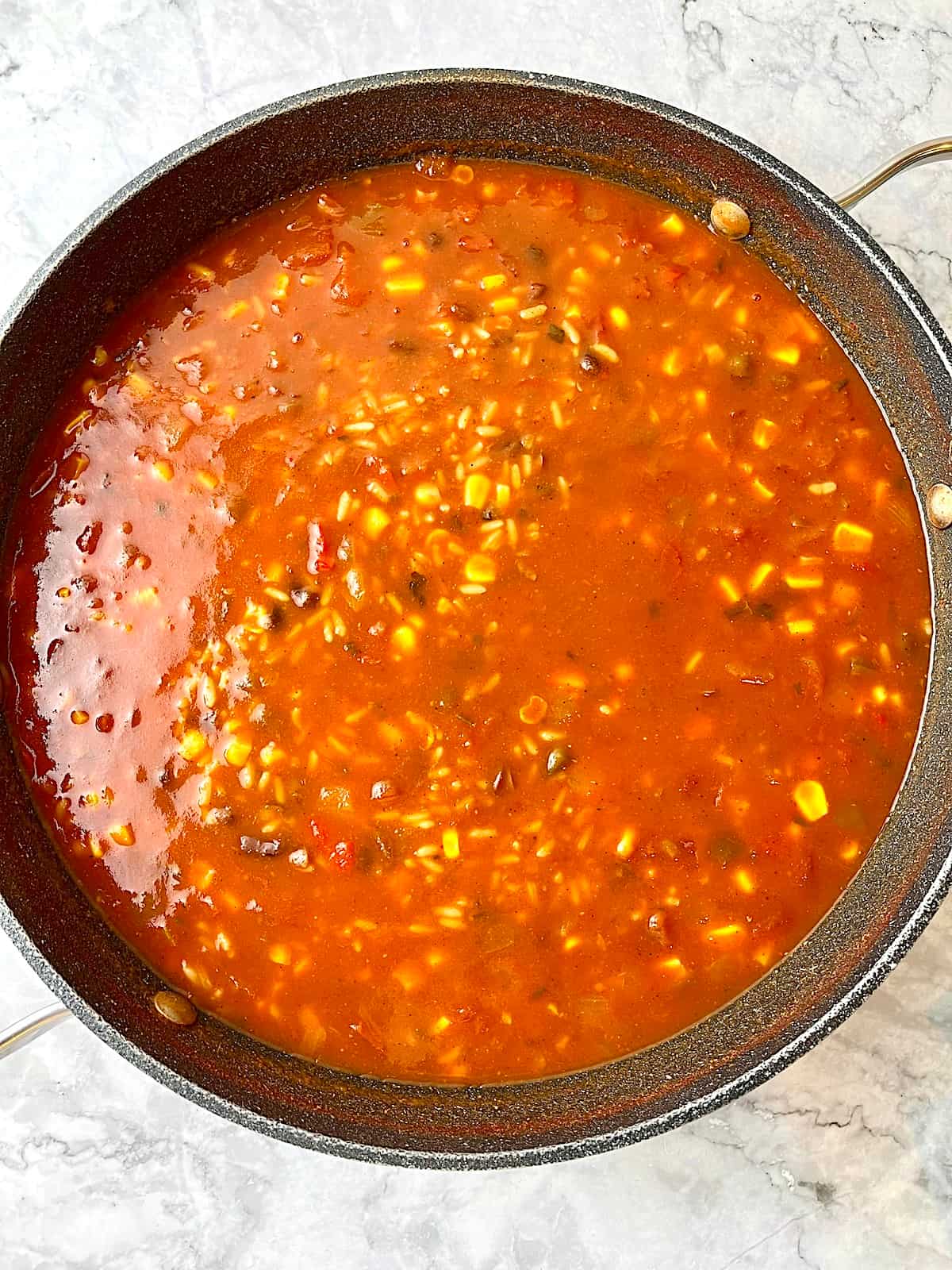 A pot of salsa soup with rice and beans.