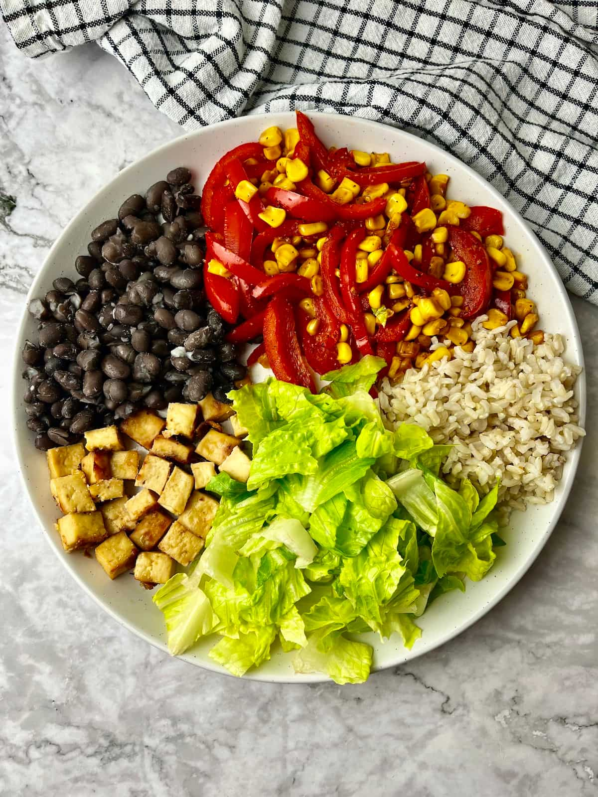 A high protein vegan bowl with black beans, veggies, rice, and tofu.