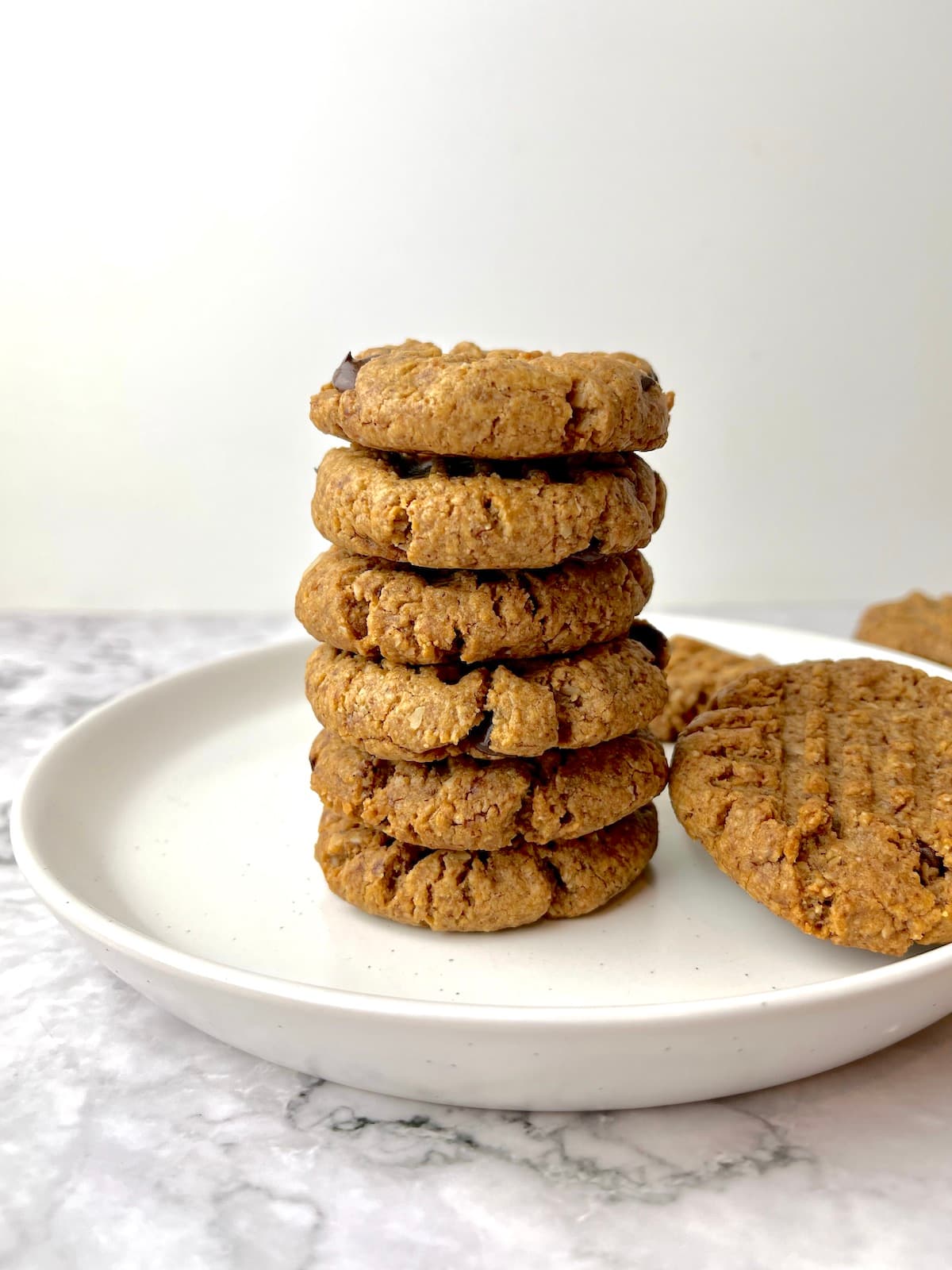 A stack of vegan almond butter cookies on a white plate.
