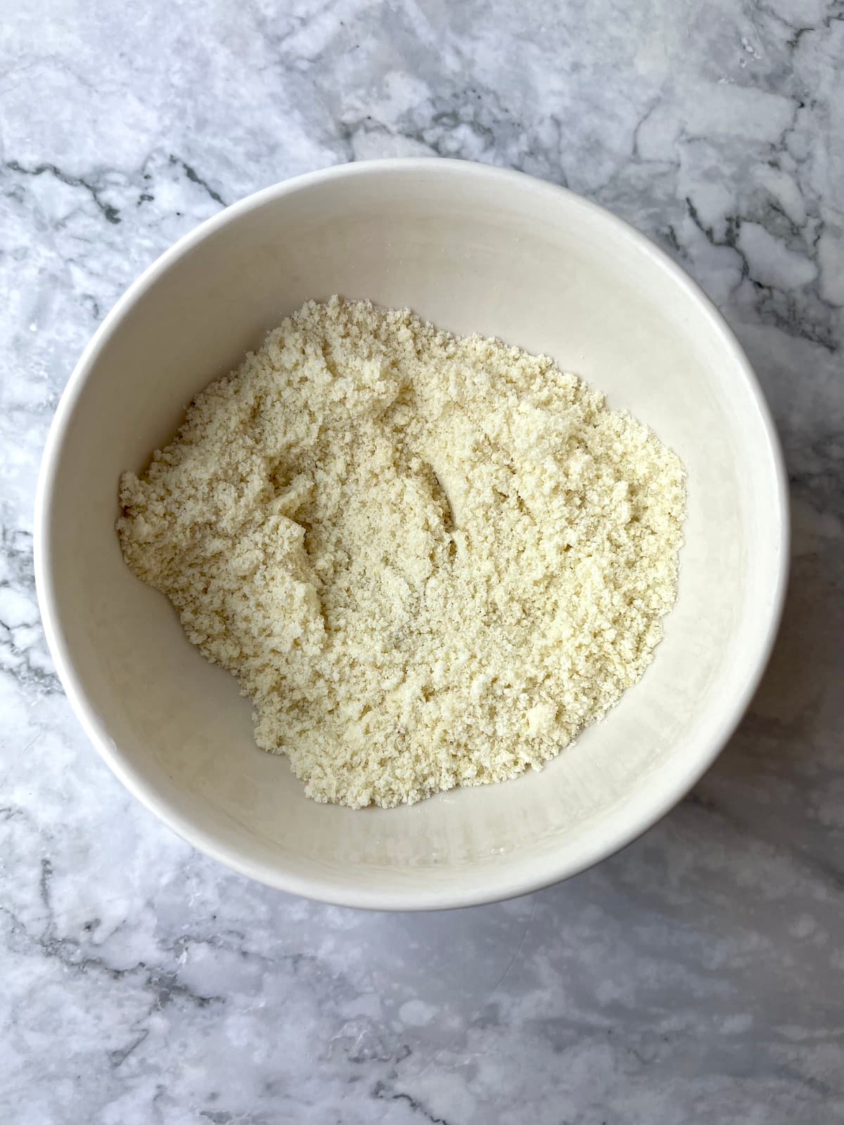 A bowl of almond flour, potato starch, sugar, and baking powder.