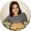 Brunette woman holding a pan of fruit crumble.